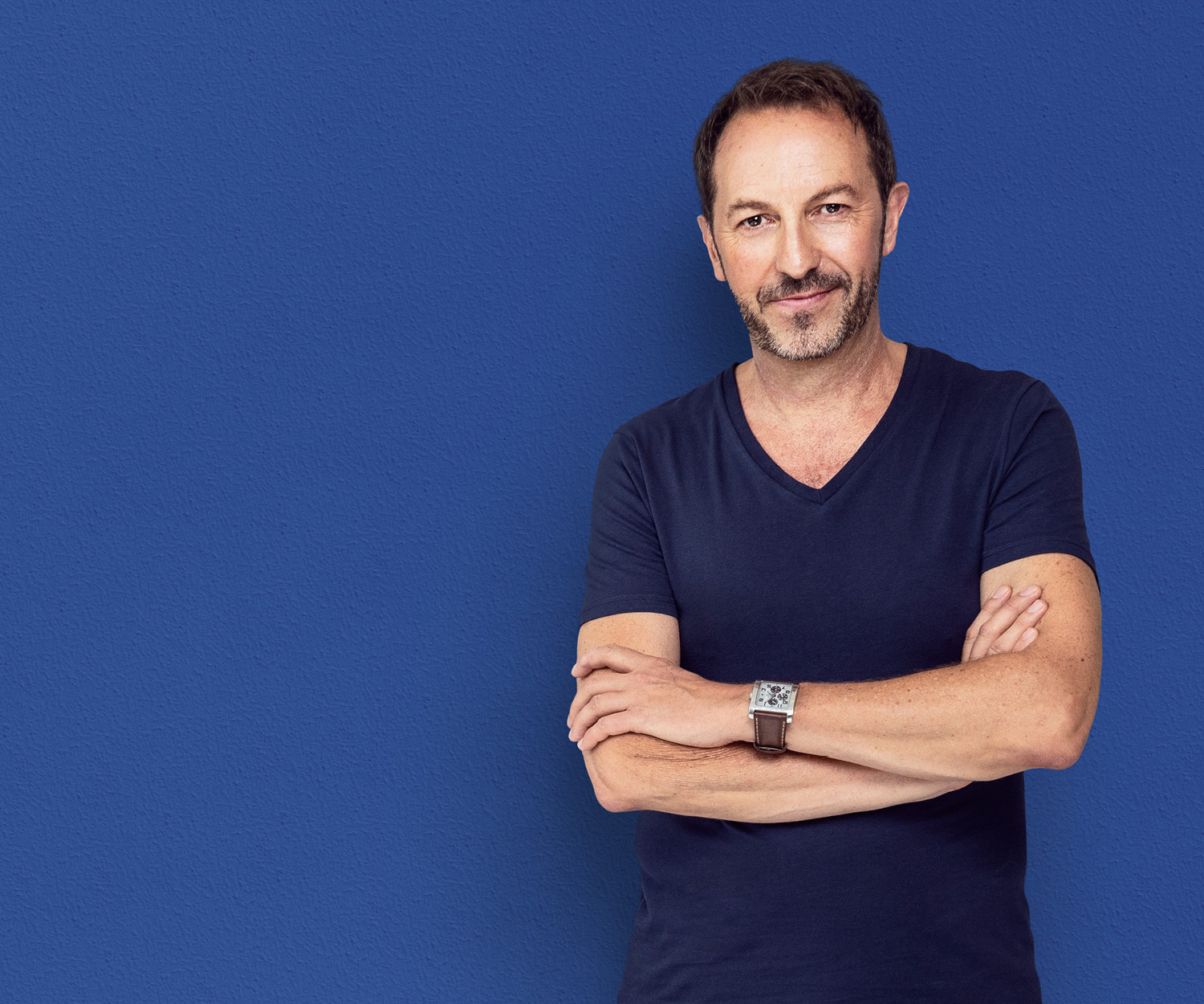 Urologe steht vor einer blauen Wand.