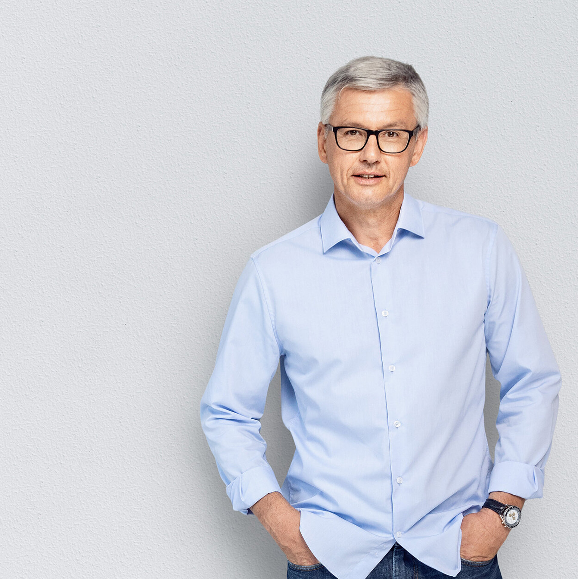 Ein Mitarbeiter aus einem Kinderwunschzentrum lehnt an einer Wand.