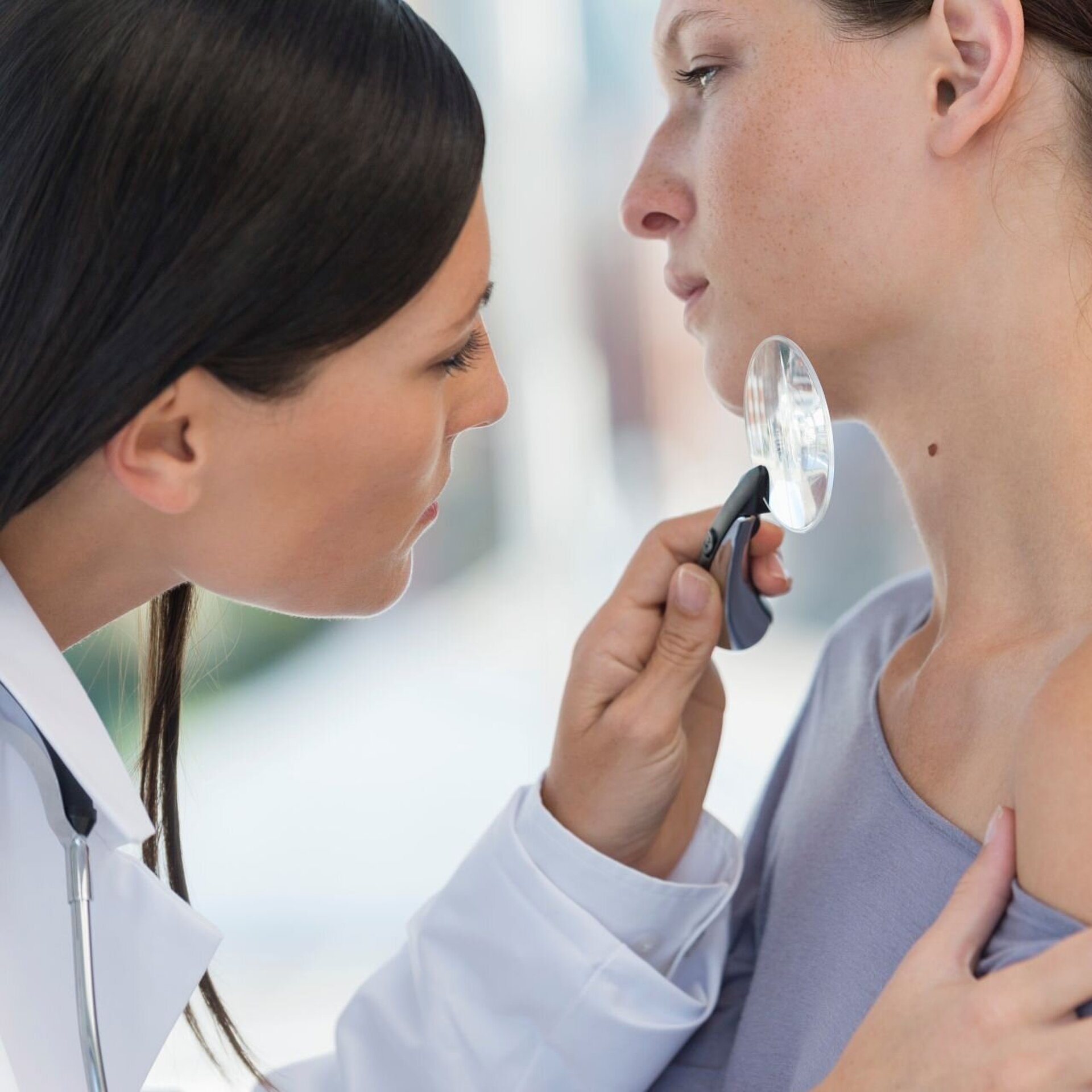Hautärztin untersucht eine auffällige Stelle am Hals einer Patientin; Symbolbild für die GOÄ-Abrechnung Dermatologie