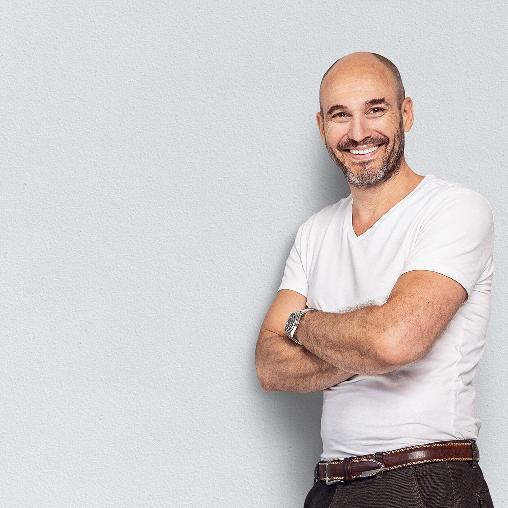 Ein Radiologe lehnt selbstbewusst an einer Wand.